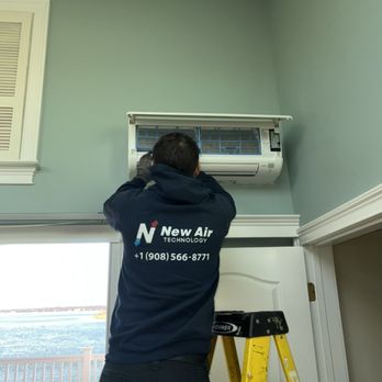 Technician troubleshooting and performing air conditioning repair on a wall-mounted mini-split system in a modern home in Bridgewater, NJ
